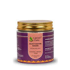 Earthy Sapo Velvety Dusting Powder in a glass jar with a gold lid.
