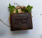 Earthy Sapo Tulsi Freshness Bathing Soap bar with fresh tulsi leaves.