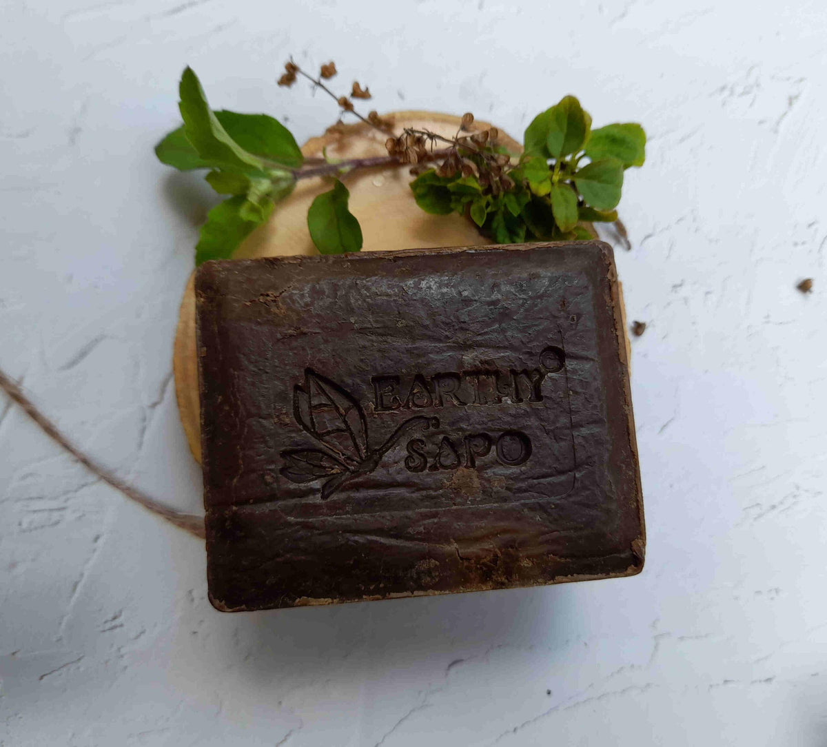 Earthy Sapo Tulsi Freshness Bathing Soap bar with fresh tulsi leaves.