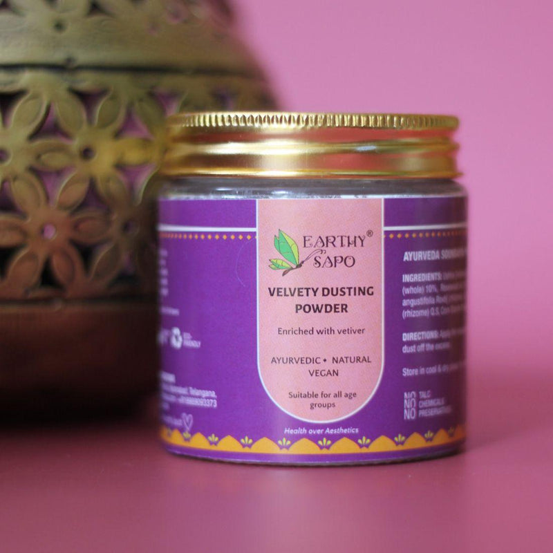 Earthy Sapo Velvety Dusting Powder in a glass jar with a gold lid.