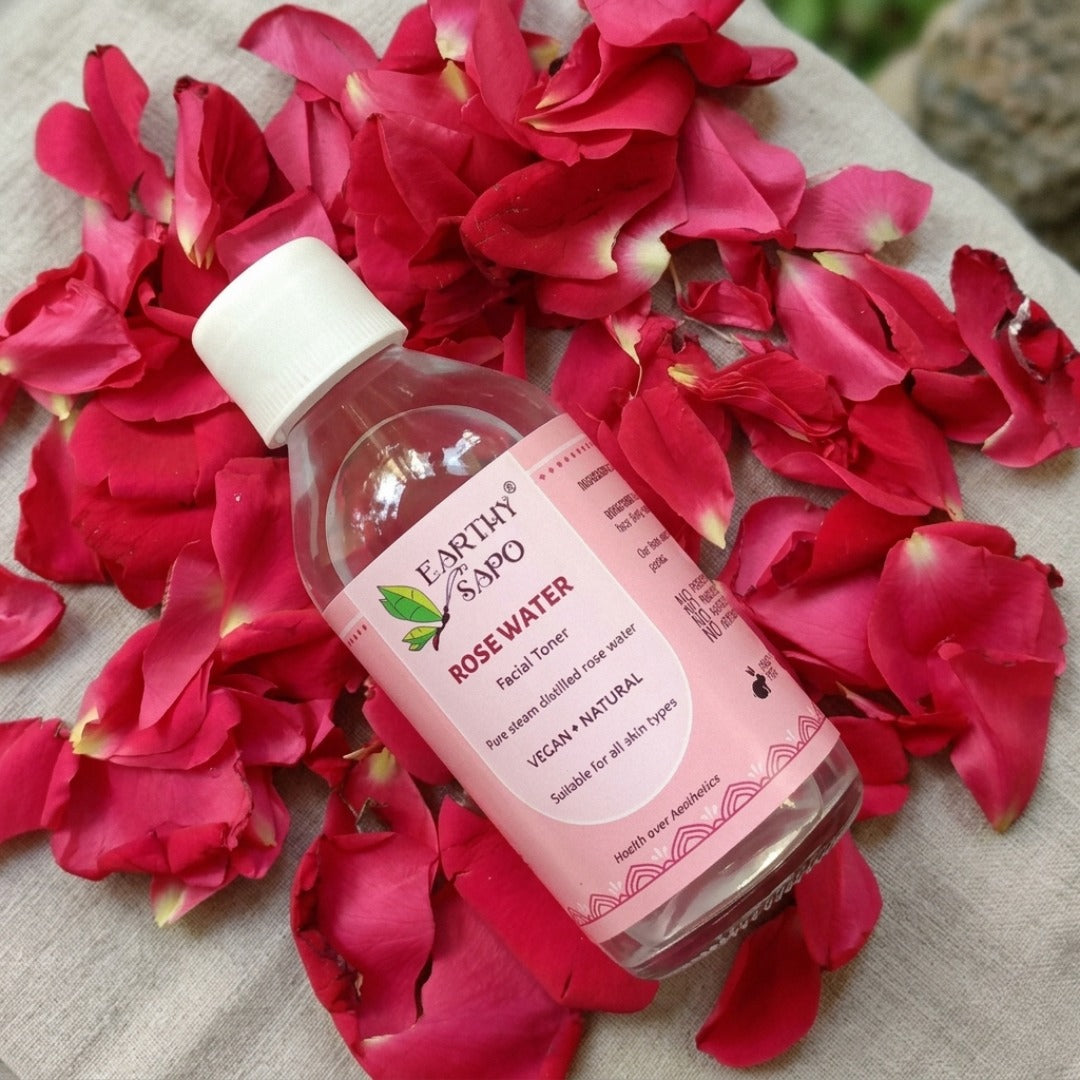 Earthy Sapo Pure Rose Water Facial Toner bottle displayed on fresh rose petals.